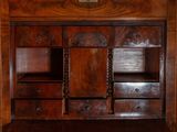 a wooden cabinet with drawers and a clock on the wall