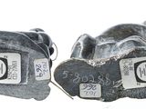 two pairs of shoes with tags on them on a white surface