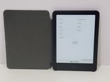 a tablet computer sitting on top of a table next to a book