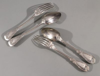 quatre cuillères en argent et deux fourchettes en argent sur une table