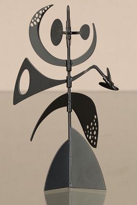 une sculpture métallique représentant un oiseau perché sur un poteau