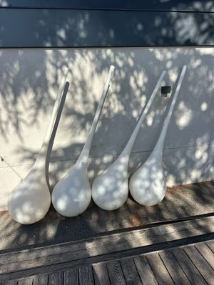 several white vases are lined up on a wooden table