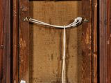 an old wooden frame with a rope hanging from it ' s side