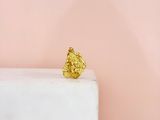 a gold leaf ring sitting on top of a white marble block