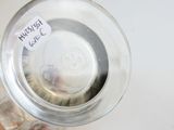 un bocal en verre rempli de pièces de monnaie et muni d'une étiquette