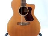 an acoustic guitar sitting on a stand against a white background