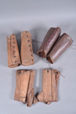 four pairs of leather boots are lined up on a gray surface