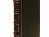 an old book sitting on top of a white table next to a white wall