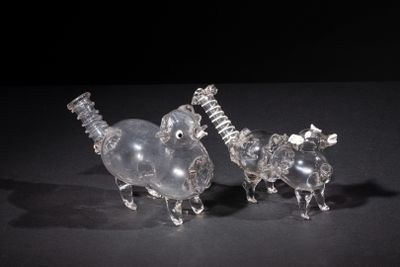 two clear glass figurines of animals on a black surface