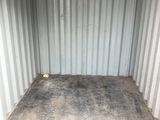 a small storage container with a metal grate on the floor