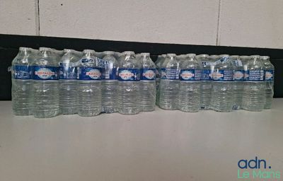 Plusieurs bouteilles d'eau sont alignées sur une table