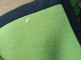 a close up of a green and black shirt on a hanger