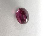 a close up of a pink stone on a white surface