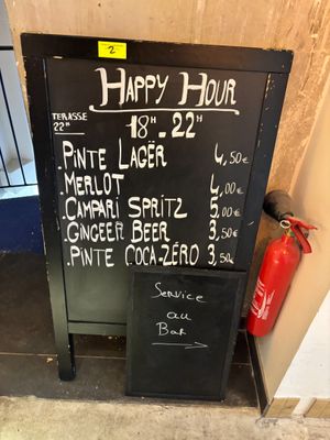 une affiche indiquant « happy hour » sur la façade d'un immeuble