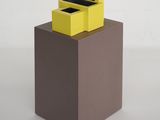 une boîte jaune surmontée de deux boîtes noires
