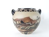 a vase with a painting on it sitting on a table