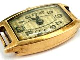 a gold watch that is sitting on a white surface