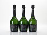 trois bouteilles de champagne posées côte à côte sur une table