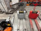 several forklifts are parked in a warehouse with pallets on them