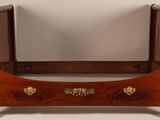 an image of a bed with a wooden frame and a mirror