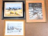 three framed paintings on a wall of a house with a stream