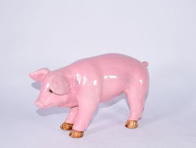 une petite figurine de cochon rose sur une surface blanche