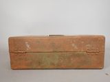 an old metal box with a handle sitting on top of a table