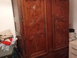 a large wooden armoire in the corner of a living room