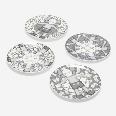 three white and black plates with designs on them on a white surface