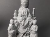 a figurine of a woman sitting on a chair with two dogs