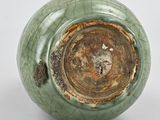 a close up of a green vase on a white surface