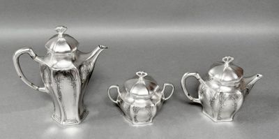 three silver teapots and a coffee pot sitting on a table