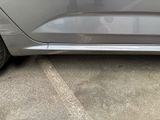 a silver car parked in a parking lot with its door open