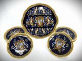four blue and gold plates with gold trims and designs on them