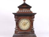 une horloge en bois posée sur une surface blanche