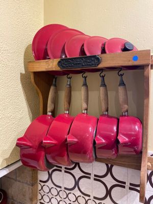 a shelf with a bunch of red pots and pans on it