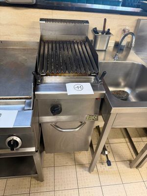 several stainless steel appliances are lined up on a tiled floor