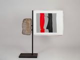 a picture of a sculpture on a stand with a red, black, and white background