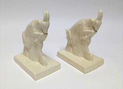 pair of white elephant bookends sitting on a white surface