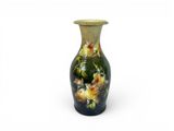 a green vase with yellow flowers painted on it