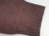 a close up of a brown sweater on a white surface