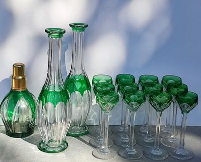 bottles and glasses are lined up on a table in front of a blue wall