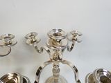 trois bougeoirs en argent posés côte à côte sur une table