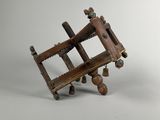 an old wooden model of a machine with wheels on a white surface