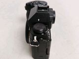 a black camera sitting on a table with a white background