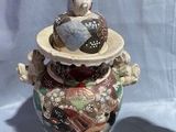 a small vase that has a bird on top of it
