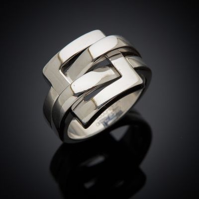 a close up of a silver ring on a black surface