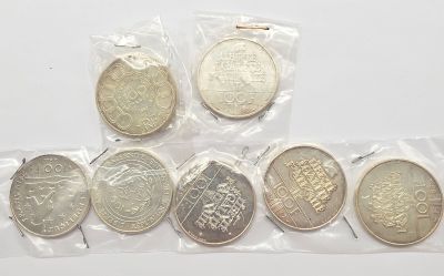 six types de pièces différents, dans des sachets en plastique, posés sur une surface blanche