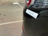 a sticker on the back of a car that is parked in a parking lot
