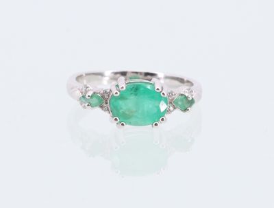 Gros plan sur une bague ornée d'une pierre verte